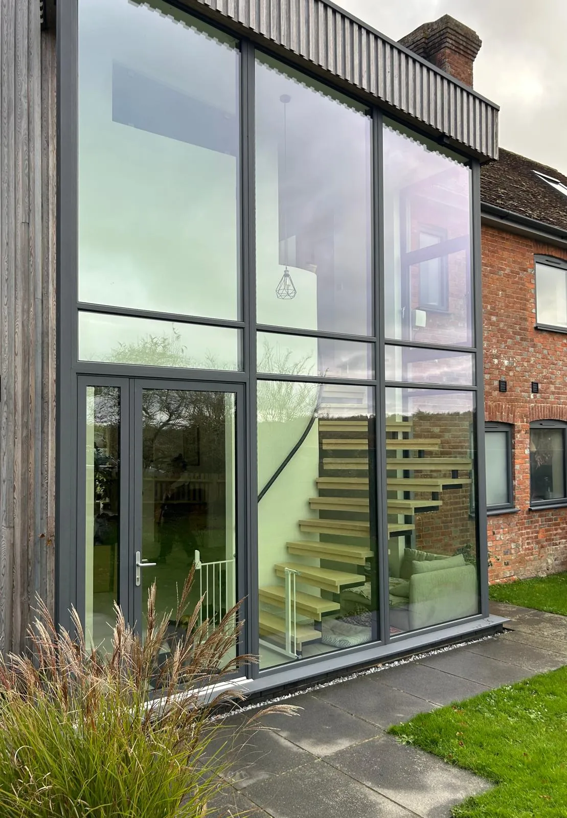 Double-height aluminium glazing around a staircase