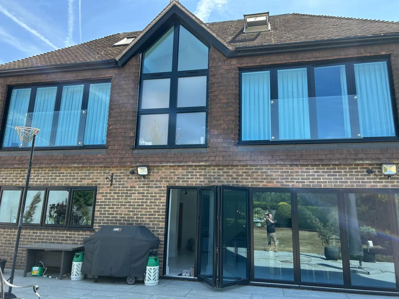 Grey aluminium windows, gable glazing and bifold doors on a family home