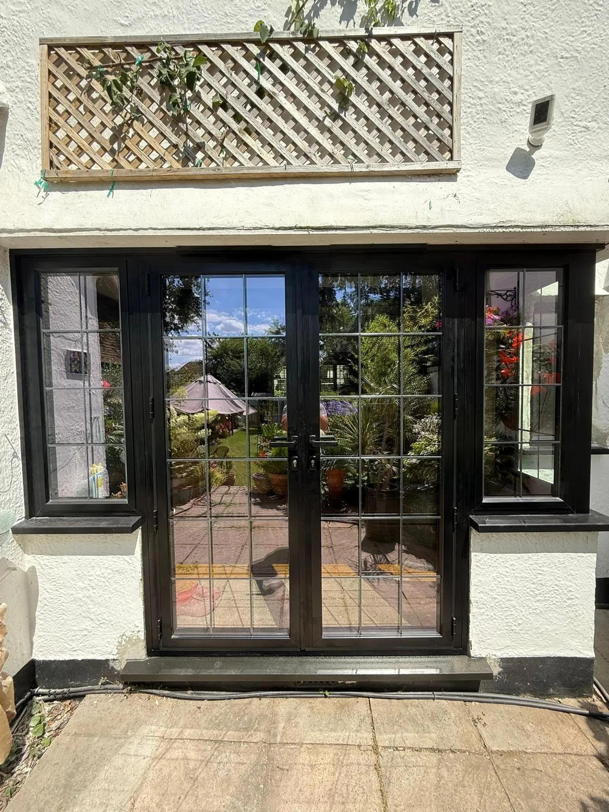 Black heritage-style French doors and side lights in a bay